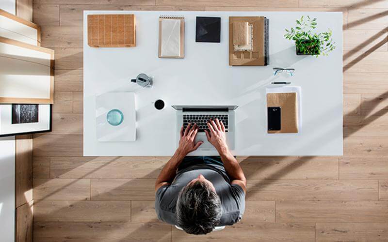 Persona trabajando en un espacio de trabajo en casa organizado y bien iluminado