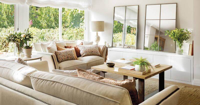 Detalles de muebles de madera clara y textiles de lino en tonos neutros en una casa preparada para el verano.