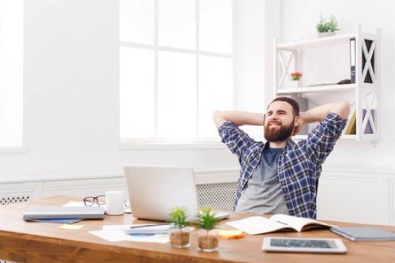 Persona tomando un descanso y estirándose en su espacio de trabajo.
