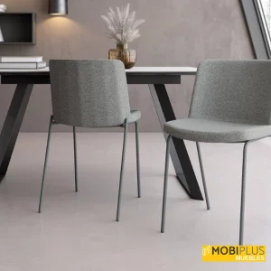 Sillas de comedor York tapizadas en tela gris con estilizadas patas metálicas en tono antracita.