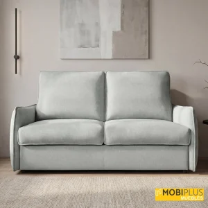 Sofá cama con sistema italiano tapizado en tela de color gris claro en un salón de tonos neutros.