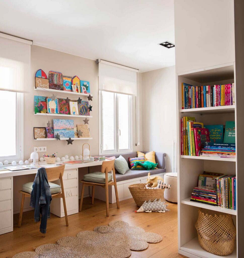 Habitación infantil decorada con alfombras, lámparas, estanterías con libros.