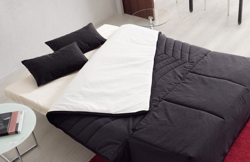 alt="Sofá cama modelo Kira 11 abierto ambiente color marengo"